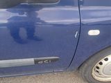 a small blue car that is parked in a parking lot