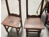 pair of antique wooden chairs with a mirror on the back of them
