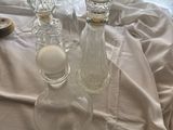 three glass vases sitting on a table with a white cloth