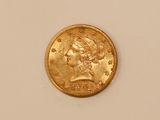 a close up of a gold coin on a white surface