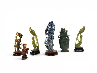 cinq figurines de formes et de tailles différentes posées sur une surface blanche