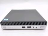 the back view of a small black computer on a white surface