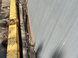 a yellow rail on the side of a building next to a street