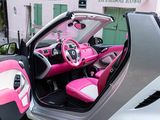 a pink and white car with its doors open