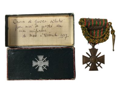 une vieille boîte sur laquelle figurent une médaille et une croix