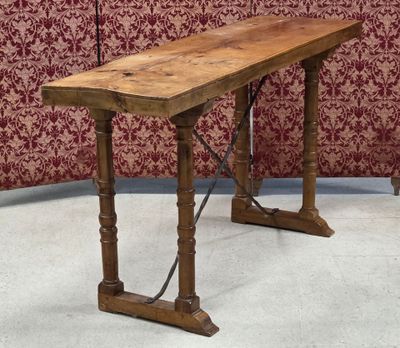a wooden table that is sitting on the floor in front of a red wall