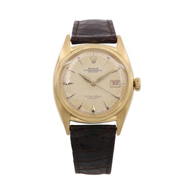 une image d'une montre-bracelet en or avec un bracelet en cuir marron