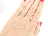 a woman ' s hand with a red manicure holding a diamond ring