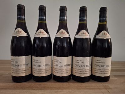 six bottles of wine are lined up on a wooden table