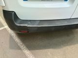 a white car parked in a parking lot with a sticker on the back of it