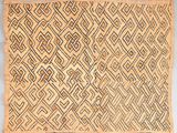 un vieux tapis tissé orné d'un motif en losanges