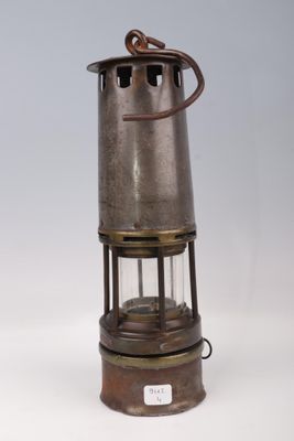 an old fashioned metal lantern with a light on top of it