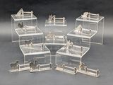 quatre boîtes transparentes représentant des chevaux, avec des chevaux à l'intérieur, posées sur une surface grise