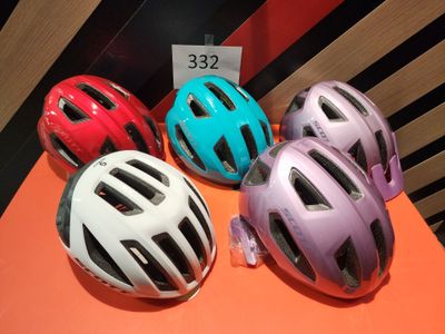 Plusieurs casques sont alignés sur une surface orange, accompagnés d'une étiquette de prix