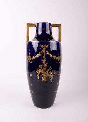 un vase bleu orné d'une décoration dorée
