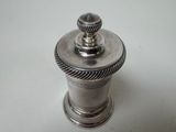 a silver pepper shaker on a white table