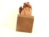 a figurine of a hand holding a wooden block