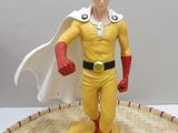 a figurine of a man in a yellow outfit and red shoes