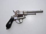 an old silver revolver with a black handle on a white surface