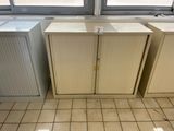 two cupboards in the corner of a room with a window