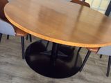 a wooden table with chairs around it in a room