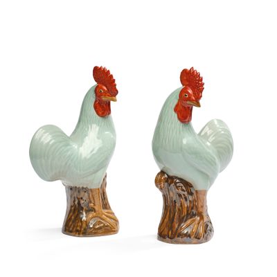 deux figurines de coq en céramique posées sur une souche d'arbre