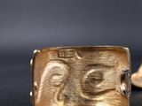 a close up of a gold ring on a black surface