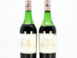 two bottles of wine sitting next to each other on a white surface