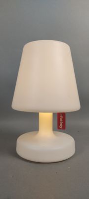 la lampe est blanche et porte une étiquette rouge