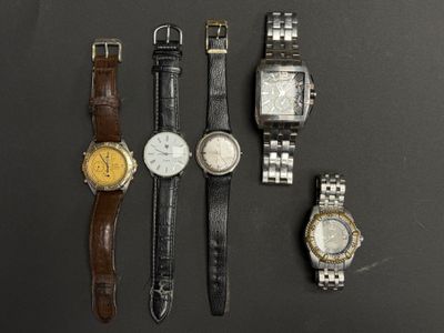 Plusieurs montres différentes sont alignées sur une surface noire