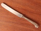 a knife on a table with a wooden surface
