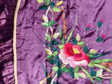 a close up of a purple jacket with a bird on it