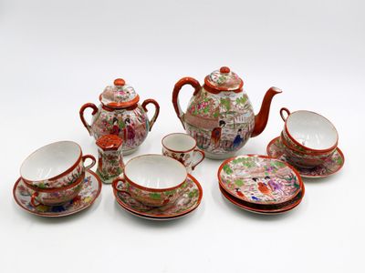 a group of teapots, cups and saucers on a white surface