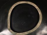 a close up of a black vase with a brown rim