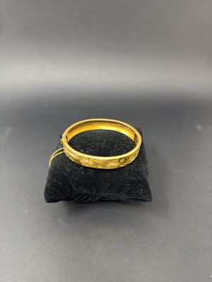 a close up of a gold ring sitting on top of a black bag