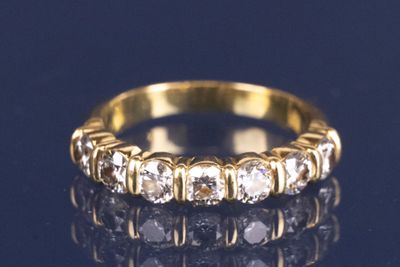 gros plan d'une bague en or avec des diamants sur une surface noire