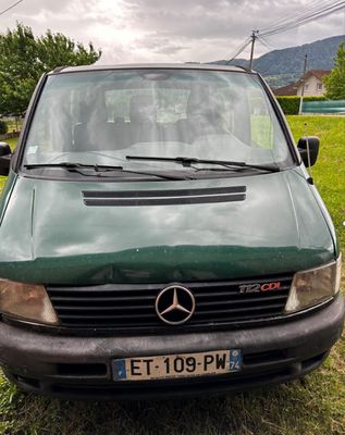 une camionnette verte garée dans l'herbe
