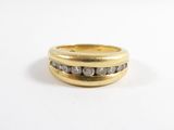 gros plan d'une bague en or avec des diamants sur une surface blanche