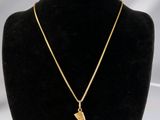 un collier plaqué or avec un pendentif en forme de tête égyptienne, présenté sur un mannequin