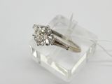 un gros plan d'une bague en diamant posée sur un morceau de verre transparent