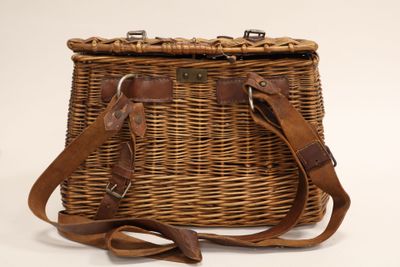 a wicker bag with a leather strap on it