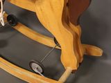 a wooden rocking horse with a rope attached to it