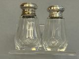 two salt and pepper shakers sitting on a clear stand