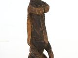 wooden statue of a man with a bird on his head