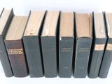 several books are stacked on top of each other on a white surface