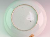 a white plate with a green rim sitting on a table