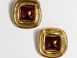 two pairs of gold and garnet stone earrings on a white surface