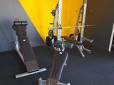 a gym room with a bench, weights, and other equipment in it