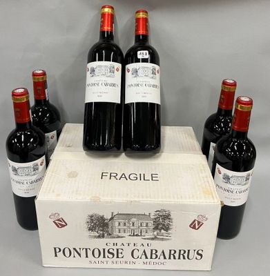 quatre bouteilles de vin rouge sont posées dans une vitrine posée sur une table