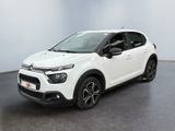 Une Citroën blanche est garée dans une pièce blanche